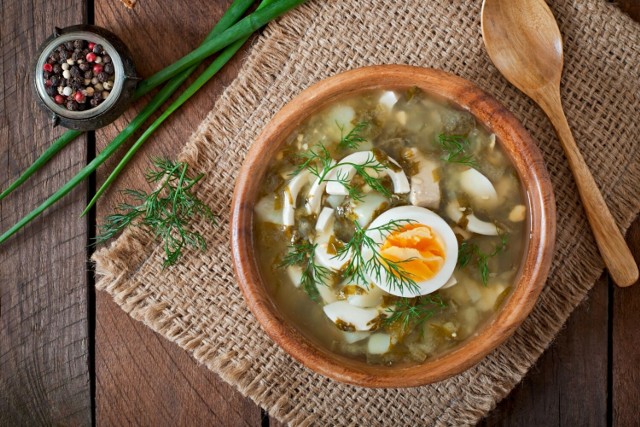 Tradycyjna zupa szczawiowa z ziemniakami znakomicie smakuje podana z kwaśną śmietaną, koperkiem i jajkiem ugotowanym na twardo.