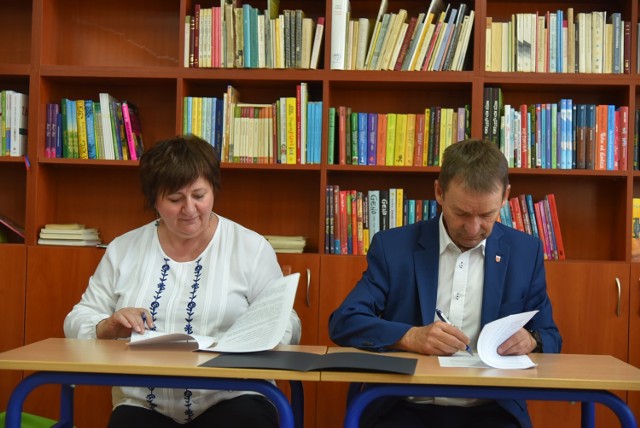 Burmistrz Leszek Tabor i skarbnik Danuta Wiatrowska podpisują dokumenty nt. dofinansowania zakupów książek dla biblioteki