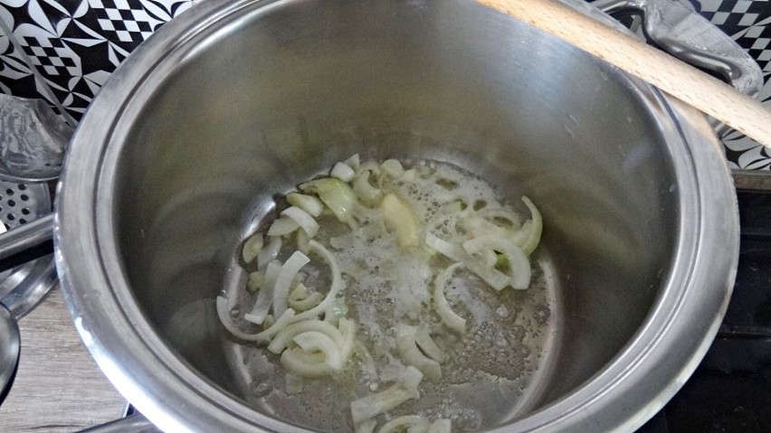 W dużym garnku rozpuść masło, dodaj cebulę i podsmaż ją na...