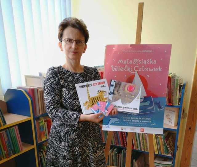 Agata Zając, pracownik Miejskiej Biblioteki Publicznej w Kielcach prezentuje wyprawki czytelnicze dla najmłodszych dzieci.