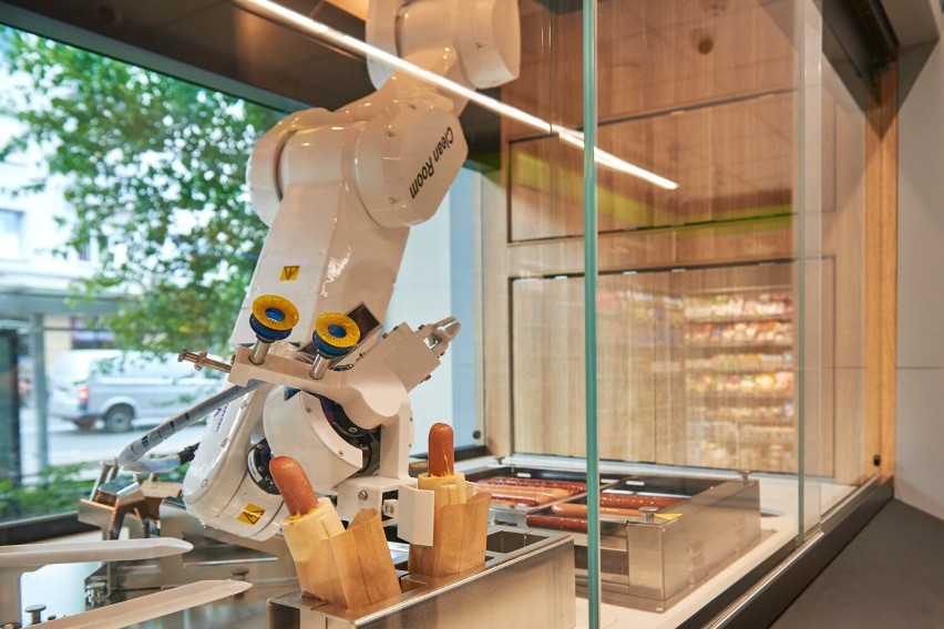 Robot składa hot-dogi z ustalonych wcześniej półproduktów.