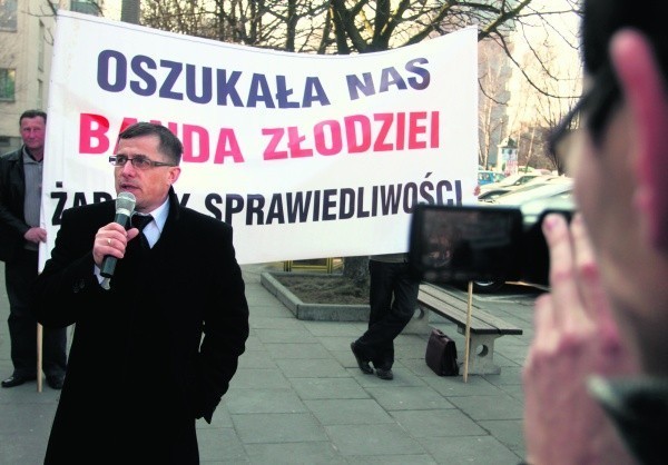 Wiceprzewodniczący rady gminy Chełmiec na tle transparentu, który oburzył przedsiębiorcę