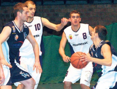 Dawid Weiss (8) i Piotr Krupa (10) próbują zatrzymać atakującego koszykarza AZS PO Opole. Fot. Jerzy Przybysz
