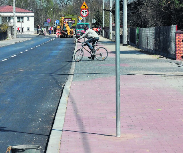 Część chodnika w kolorze cegły należy do rowerzystów... i znaków drogowych