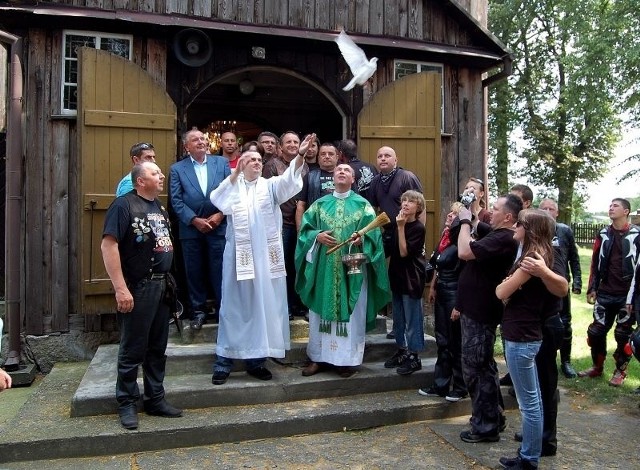 Ks. Sławomir  Nowak (w ornacie)  święci gołębia pokoju podczas zeszłorocznego zjazdu motocyklowego szlakiem drewnianych kościołów