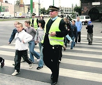 Strażnik Arkadiusz Kamiński uczy dzieci bezpiecznego poruszania się po ulicach