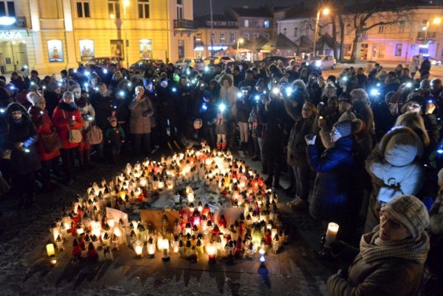 

Kilkaset osób przybyło w mroźny, niedzielny wieczór na kielecki Rynek, aby w ramach spotkania "Murem za Owsiakiem" wyrazić swą solidarność z twórcą, z sercem i ponownie prezesem Wielkiej Orkiestry Świątecznej Pomocy. Już przed godziną 17 na płycie Rynku gotowe było płonące serce wykonane z kilkudziesięciu lampek - przynoszono kolejne. Wiele z nich miało przyklejone serduszko Orkiestry, a w tle umieszczono zdjęcia zamordowanego tydzień temu prezydenta Gdańska.  



   Po godzinie 18 organizatorzy spotkania poprosili zebranych, by przeszli od płonącego serca w inne miejsce i zapalili światełka telefonów, latarek, zapalniczek - tak, aby można było wykonać zdjęcie z góry, z drona, które zostanie przesłane Jurkowi Owsiakowi. - Niech wie, że z nim jesteśmy, on jest z nami od 27 lat - mówił organizator spotkania Maksymilian Materna. Minutą ciszy zebrani uczcili pamięć zmarłego prezydenta Gdańska. Nie było żadnych przemówień bowiem organizatorzy uznali, że w ostatnich dniach było ich wystarczająco wiele. Podziękowano Urzędowi Miasta Kielc za pomoc w organizacji spotkania. Jako że mróz dawał się we znaki z głośników zagrano klasyczne przeboje rocka, by zgromadzeni mogli się rozgrzać tańcem- co wielu uczyniło z ochotą. Były też owacje dla Jurka Owsiaka. Na Rynek przyszły całe rodziny z małymi dziećmi, większość miała przylepione do ubrań czerwone serduszka WOŚP.

Księga kondolencyjna Pamięci Pawła Adamowicza