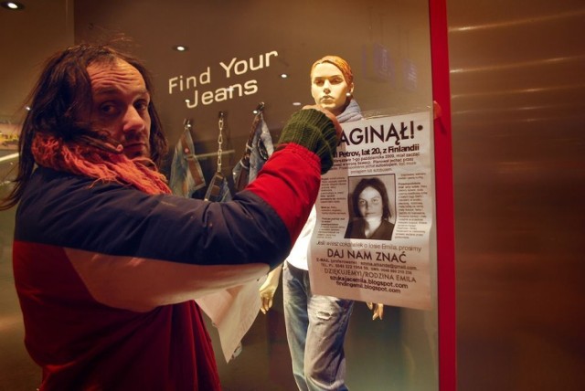 Ojciec zaginionego David Petrov przykleja plakat ze zdjęciem syna na witrynie sklepu w Galerii Krakowskiej