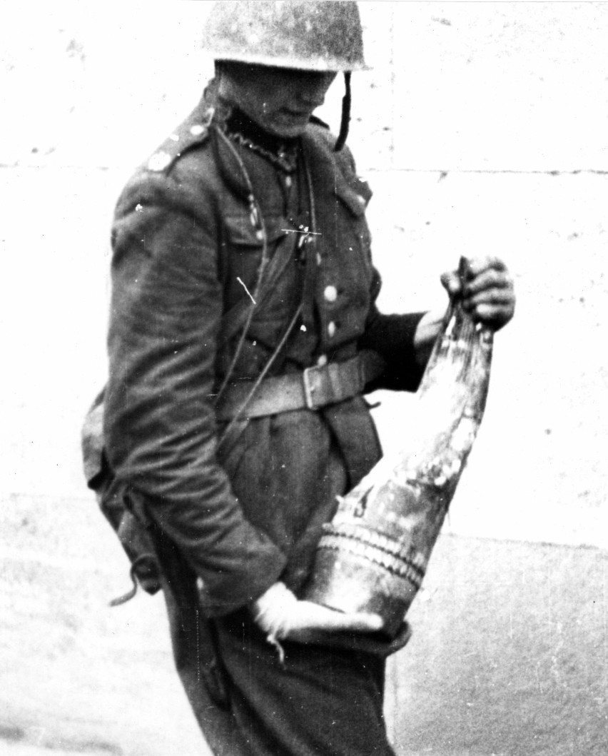 Żołnierz polski trzymający niemiecki niewypał.