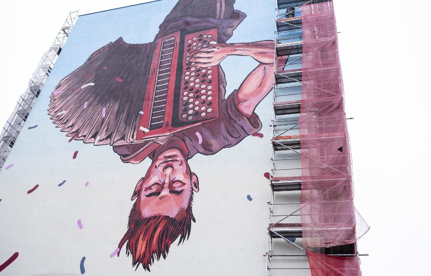 Nowy mural w Warszawie. Uliczny grajek do góry nogami