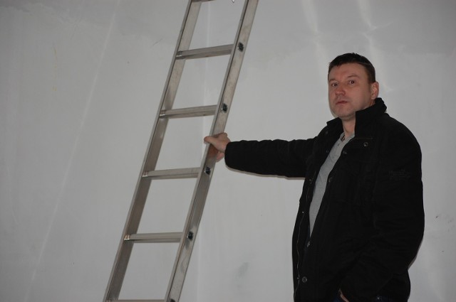 Grzegorz Skonieczny pokazuje drabinę, która w kosztorysie jest schodami za kilka tysięcy złotych.