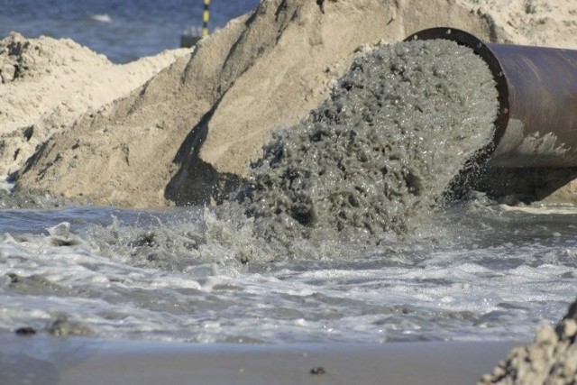 Z piaszczystego dna morskiego za pomocą specjalnych urządzeń piasek przepompowywany jest rurociągiem na plażę.