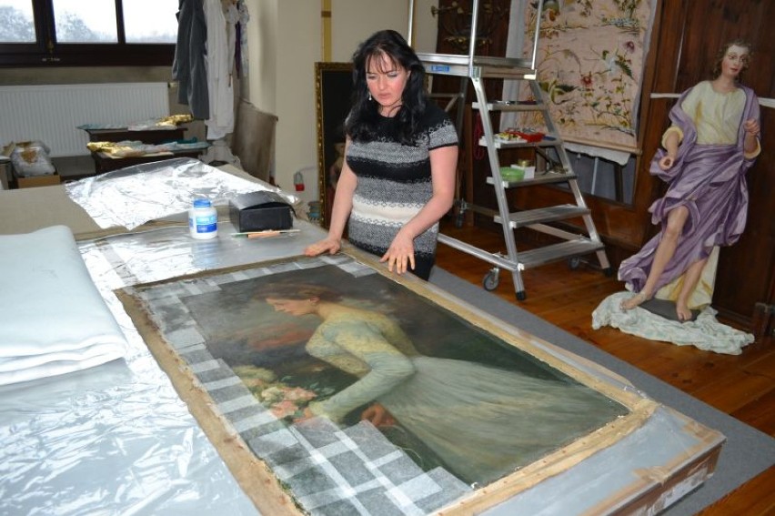 Paulina Drobisz konserwuje jeden z obrazów w pracowni