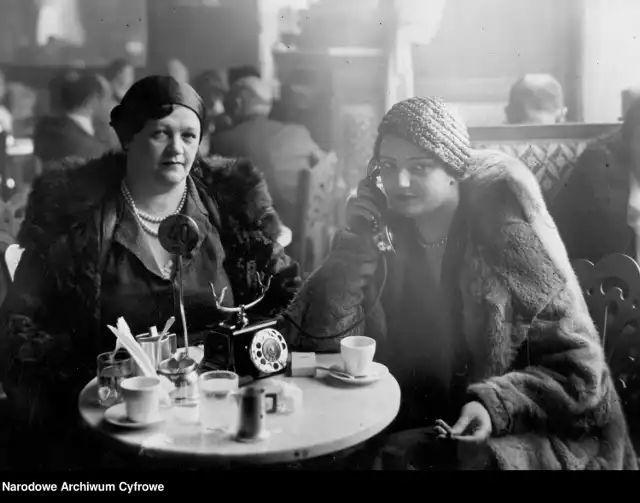 Restauracja w Warszawie, goście restauracji siedzący przy stolikach. Na pierwszym planie widoczne dwie kobiety, jedna z nich rozmawia przez telefon stojący na stoliku, sygnatura: 3/1/0/8/7126