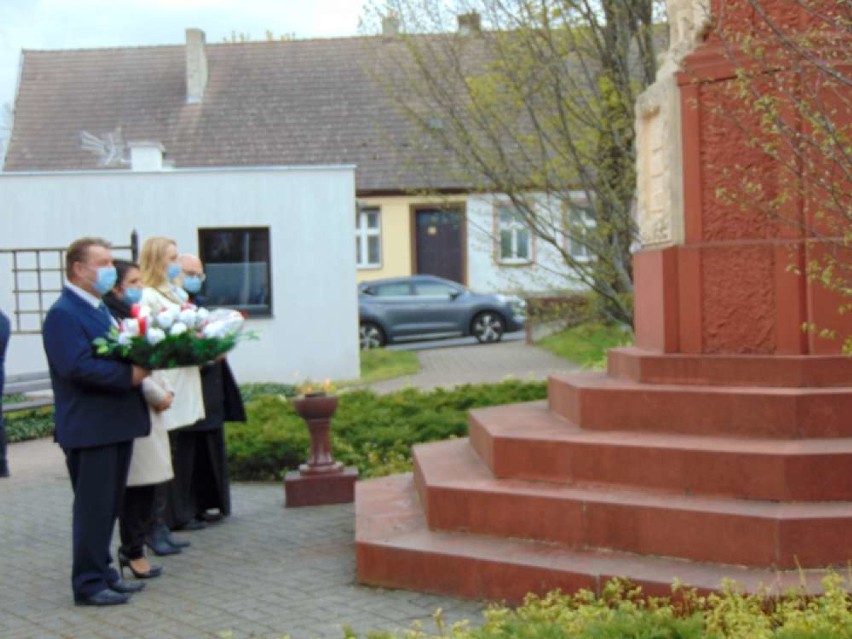 Burmistrz Eugeniusz Kucner składa kwiaty przy pomniku.