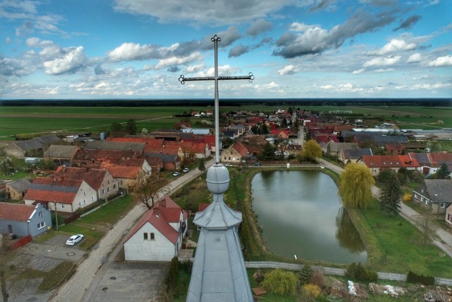 Niewielki, ale uroczy stawek z dwoma kładkami. W jego tafli odbija się pobliski kościół, a wokół, prostopadle do ulic skupiają się domy jednorodzinne. Tak wygląda centrum wsi Rogoziniec z lotu ptaka.

Rogoziniec znajduje się nieco ponad 20 kilometrów od Świebodzina. Niedaleko biegnie autostrada A2, z której można zjechać do pobliskiego McDonalda. Jednak już dwa kilometry dalej, wśród pól, rozciąga się wioska o średniowiecznej metryce.

Rogoziniec to wieś królewska. Pierwsze wzmianki o niej pochodzą z 1425 roku - wówczas Władysław Jagiełło zastawił Rogoziniec Abrahamowi Zbąskiemu. Wieś była zastawiana również w latach kolejnych. Do dziś przetrwał układ gruntów z XVI wieku.

Rogoziniec słynie jednak przede wszystkim z technikum leśnego. Szkoła ma już ponad 70 lat i mieści się w budynkach dawnych koszar Cesarskich Niemiec sprzed I wojny światowej. Internat dysponuje 170 miejscami. 

Dzięki naszemu Czytelnikowi Grzegorzowi Walkowskiemu możemy oglądać Rogoziniec z lotu ptaka. Sprawdź, jak wioska przedstawia się wioska z tej niecodziennej perspektywy!