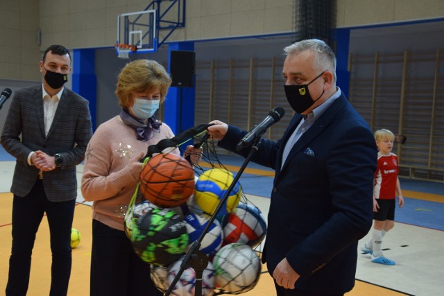 Dyrektor SP1 Szczecinek Krystyna Dianow odbiera od burmistrza Daniela Raka piłki na dobry początek działalności nowej hali