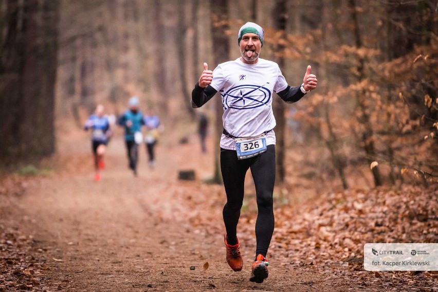 Duzi i mali biegacze na leśnej trasie zawodów City Trail...