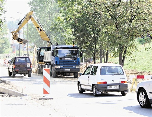 Samochody jadą aleją, choć prace remontowe obok trwają