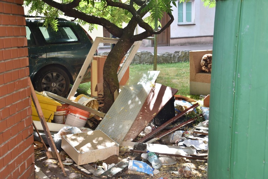 Podwórko w centrum Oleśnicy, a w nim sterta śmieci i śpiący kloszardzi 