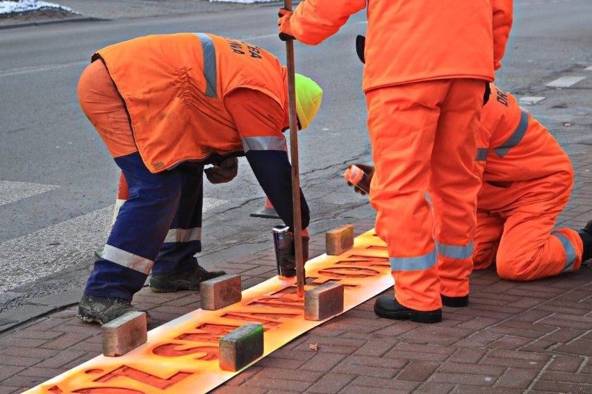 Przy przejściach dla pieszych w Kraśniku pojawiły się fluorescencyjne napisy. Trwa akcja "Odłóż smartfon i żyj!"