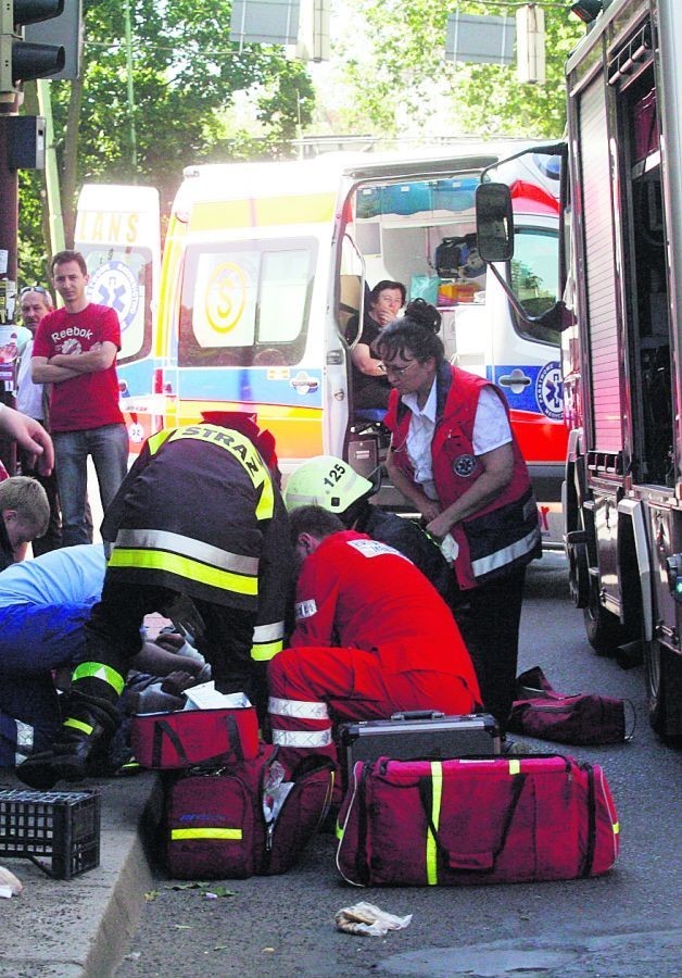 Ratownicy opatrują rannych po uderzeniu radiowozu