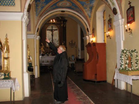 Ksiądz Jan Włodarczyk pokazuje czujniki antywłamaniowe w chruszczobrodzkim kościele.