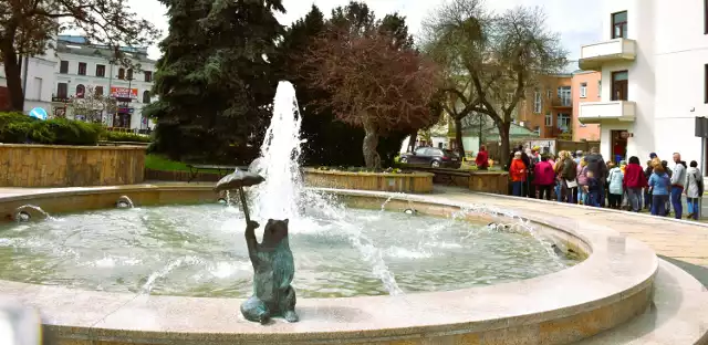 Na murku miejskiej fontanny na placu Gdańskim jest figura siedzącego niedźwiadka z parasolem.