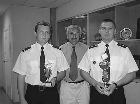 Rafał Benedykciński (po lewej) i Grzegorz Kuroszczyk (po prawej) prezentują zdobyte nagrody. W środku rzecznik ostrowskiej policji Edward Cukiernik.