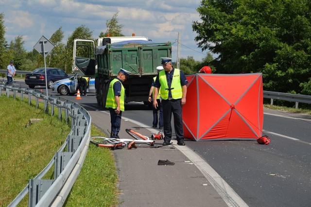 Na ścieżce rowerowej leży rower ofiary, jego ciało strażacy zasłonili parawanem, dalej ciężarówka, która potrąciła rowerzystę.