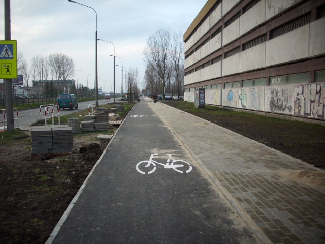 Nowy chodnik i ścieżka rowerowa wzdłuż ulicy Sosnkowskiego. Po prawej wielopoziomowy parking osiedla AK.