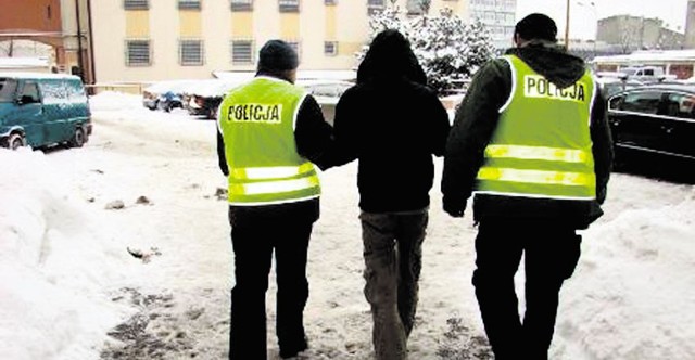 Policjanci prowadzą 36-latka, który napadł na siedem banków, rabując w sumie 70 tysięcy złotych