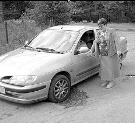Gabriela Głogowska pokazuje makabryczne dziury w jezdni. Fot: Olgierd Górny