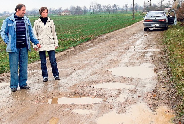 Grażyna i Grzegorz Stolarczykowie pokazują drogę, na której wg wójta położono już asfalt