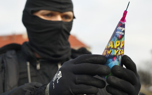 Policjant antyterrorysta demonstruje, jak należy bezpiecznie obchodzić się z fajerwerkami.