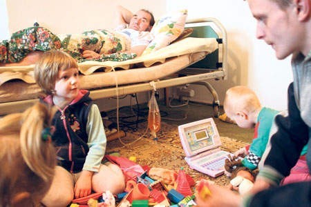 W pokoju obłożnie chorego ojca Kingi Kaboczyk bawią się dzieci. Na zdjęciu pod opieką taty (po prawej).