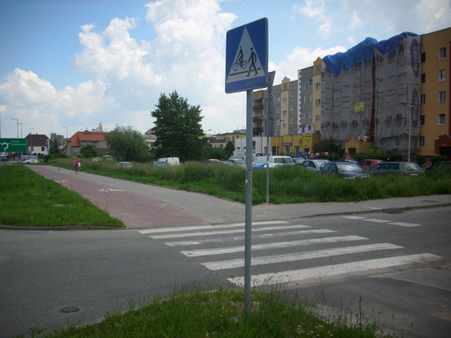 Kierowco zwolnij! Znak mówi, że zbliżasz się do przejazdu dla rowerów i przejścia dla pieszych.