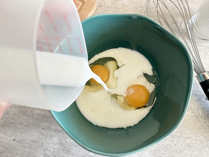 Wlej do jajek mleko. Zacznij mieszać mikserem lub rózgą...