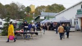 Różności na Targowisku Miejskim w Ostrowcu Świętokrzyskim. Na stoiskach kurtki, czapki i instrumenty muzyczne 