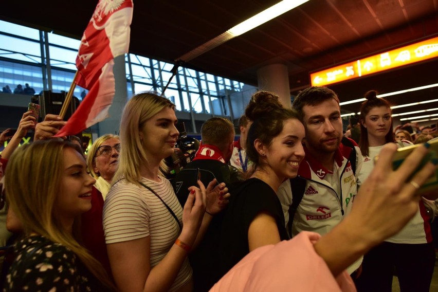 Powitanie siatkarzy na lotnisku w Warszawie. Tłumy kibiców przywitały mistrzów świata. Była orkiestra, śpiewy i flagi [ZDJĘCIA] 