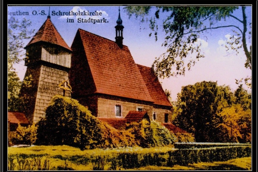 Pocztówka przedstawia kościółek drewniany w parku miejskim....