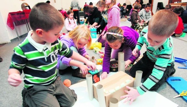 Grupa dzieci buduje zamek z plastiku i tektury w Muzeum Architektury