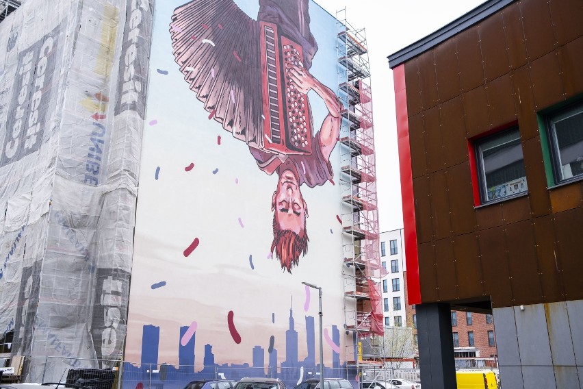 Nowy mural w Warszawie. Uliczny grajek do góry nogami