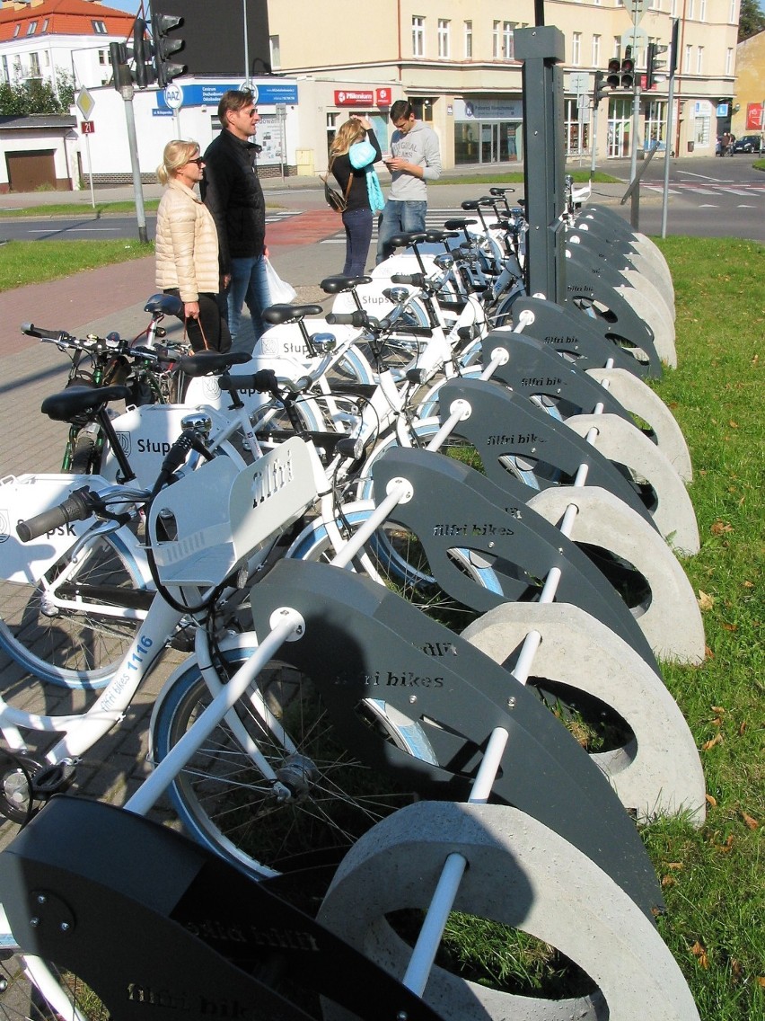 Tuzin rowerów miejskich zaparkowanych na stacji przy Rondzie...