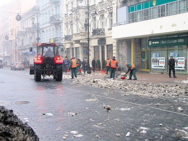 Brudny śnieg leżący na chodniku był rzucany na jezdnię.