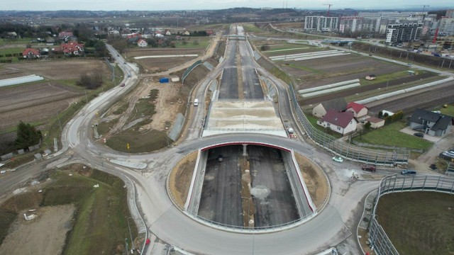 Postępy na budowie Północnej Obwodnicy Krakowa: Mosty 94 proc., tunele 94 proc., wzmocnienie gruntu 93 proc., konstrukcje oporowe 96 proc. - to oznacza, że gdy te konstrukcje będą niebawem gotowe przyspieszy budowa jezdni, które je połączą. Na razie jeśli chodzi o podbudowę drogi i asfalt mamy zaawansowanie na poziomie 66 proc.  Przewidywany termin to wrzesień 2024 roku.