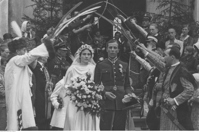 Para młoda opuszcza kościół po ceremonii zaślubin przechodząc pod szpalerem szabel trzymanych