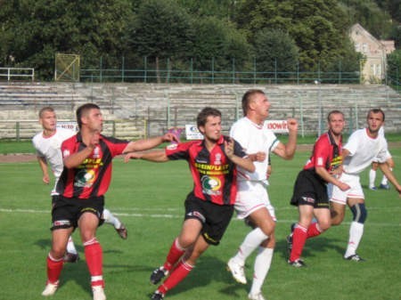 Paweł Załoga (na środku, biała koszulka) walczy o piłkę z piłkarzem Korony. Fot. www.mkspolonia.pl