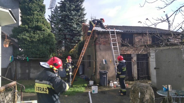 Strażacy zabezpieczają uszkodzony dach