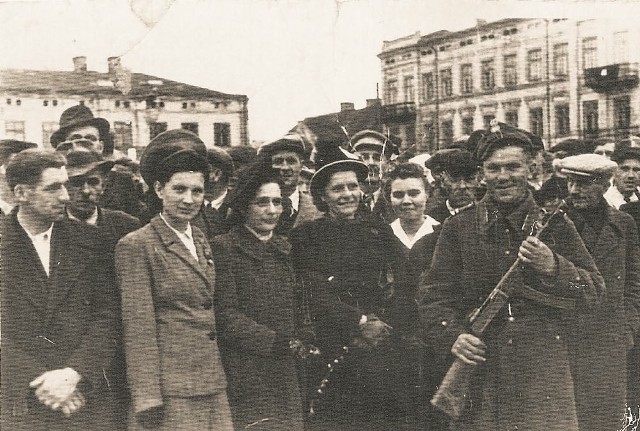 Jeden z żołnierzy 14 Brygady Artylerii Przeciwpancernej witany na pl. Kościuszki w Tomaszowie. Maj 1945 r.